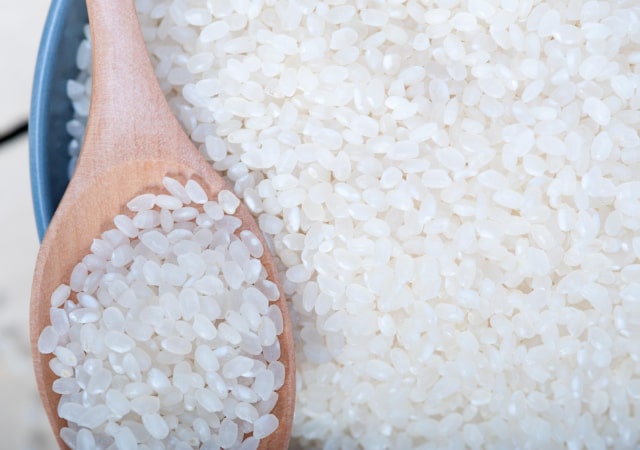 Image of rice grains with a wooden spoon